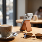 Phone propped on a cafe table by its Folio MagSafe card-holder kickstand